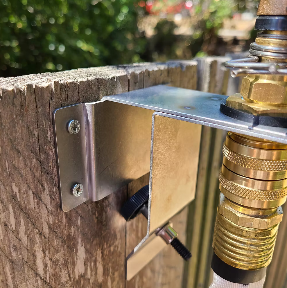 EmberHawk structure-mount steel bracket screwed to a wood post with brass quick-connect fittings